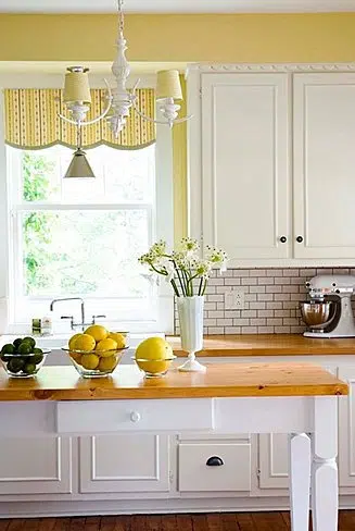 Cheery yellow walls bring this kitchen to life via Nicola Marc